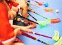 Children playing floorball. Boys holding floor ball sticks resting on the bench during a match